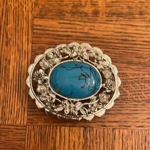 Metal belt buckle with a man-made stone